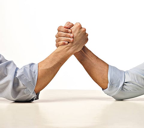 two business people competing in arm wrestling