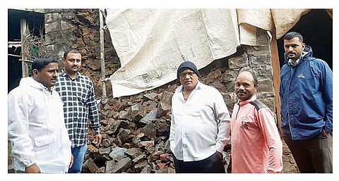 अतिवृष्टीत कोसळलेल्या घरांच्या भिंतीचे पंचनामे करताना अधिकारी.