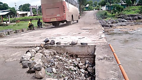 कळवण : ककाणे ते खेडगाव रस्त्यावरील पुलाला पडलेले मोठे भगदाड आणि त्यावरून धोकादायक स्थितीत सुरू असलेली बसवाहतूक. (छाया : बापू देवरे)