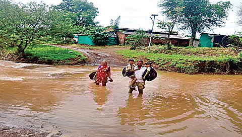 दिंडोरी : जोरण येथील विद्यार्थ्यांना घेऊन नदी ओलांडताना पालक. (छाया : समाधान पाटील)