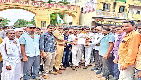 नामपूर : येथील बाजार समितीसमोर कांदा बाजारभावप्रश्नी आंदोलन करताना शेतकरी.