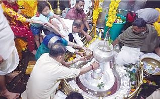 भीमाशंकर येथील पवित्र शिवलिंगावर अभिषेक करताना भाविक.