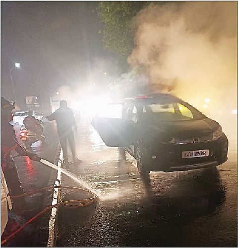 चारचाकीवर पाण्याचा फवारा मारताना अग्निशामक दलाचे जवान.