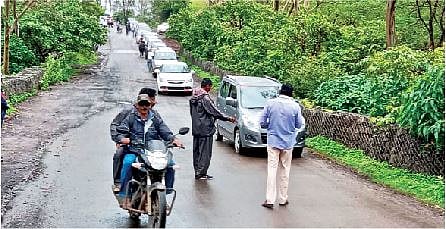 सिंहगड घाटरस्त्यावर वाहतूक नियोजन करताना सुरक्षारक्षक.