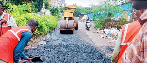 धायरीत रायकरमळा, जाधवनगर परिसरातील रस्त्यावर पडलेले खड्डे बुजवून डांबरीकरण करताना कामगार.
