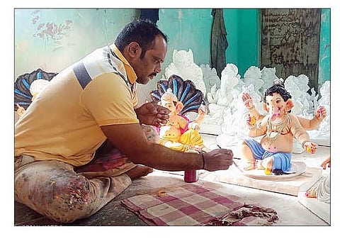 जेजुरी येथे गणेशमूर्तींवर रंगरंगोटी करताना मूर्तिकार तुषार कुंभार.