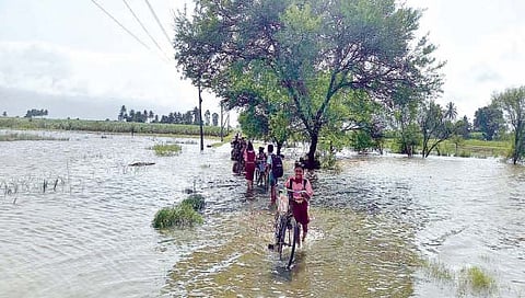 इंगळी : कृष्णा नदीला आलेल्या पुरातून वाट काढताना नागरिक.