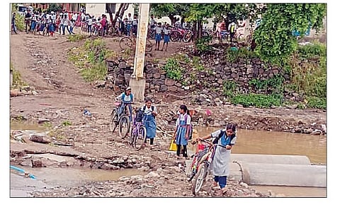 नगर तालुका : वाहून गेल्या पुलावरून वाट काढताना विद्यार्थीनी.