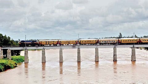 सांगली : कृष्णा नदीचे तुडुंब भरलेले विस्तीर्ण पात्र आणि पुलावरून धावणारी रेल्वे. अंकली पुलावरून टिपलेले छायाचित्र! (छाया : सचिन सुतार)