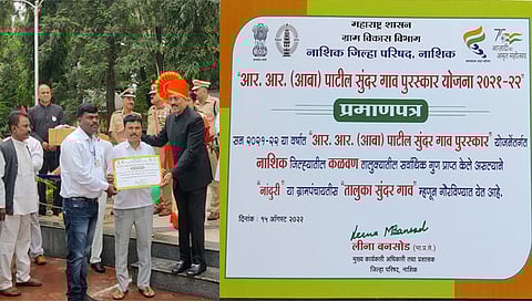 अभोणा : राज्याचे ग्रामविकासमंत्री ना. गिरीश महाजन यांच्या हस्ते स्मार्ट ग्राम पुरस्कार स्वीकारताना सरपंच सुभाष राऊत व ग्रामसेवक पंडित महाजन. (छाया : सचिन मुठे)