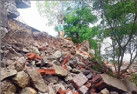 बेल्हे येथील जिल्हा परिषद शाळेच्या संरक्षक भिंतीचा कोसळलेला भाग.