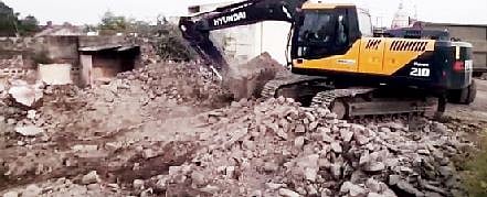 रोटी (ता. दौंड) येथे संत तुकाराम महाराज पालखी महामार्गाच्या रस्ता रुंदीकरणाच्या कामात घरे पाडताना पोकलेन मशिन.