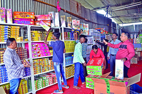 नाशिक : डोंगरे वसतिगृह लावण्यात आलेल्या दुकानांत फटाक्यांची मांडणी करताना विक्रेते. (छाया ः हेमंत घोरपडे)