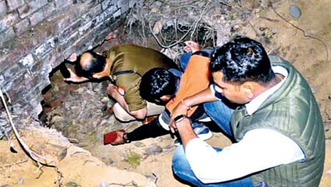 कानपूर : स्टेट बँक ऑफ इंडियाच्या बँकेची स्ट्राँग रूम फोडून आतील एक कोटी रुपयांचे सोने लंपास करण्यासाठी चोरट्यांनी खणलेल्या भुयाराची पाहणी करताना पोलिस अधिकारी.