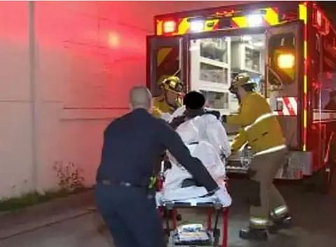 गोळीबारात जखमी झालेल्यांना रुग्णालयात हलविताना कर्मचारी.