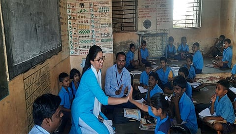 नंदूरबार : अपेक्षित उत्तर मिळाल्याने विद्यार्थींनी पूजा हीला टाळी देत उत्स्फूर्त संवाद साधत असताना प्रकल्प अधिकारी मीनल करनवाल. (छाया : योगेंद्र जोशी)