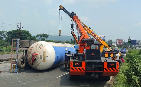 फोटो ओळ : पुणे-सातारा महामार्गावर हरिश्चंद्री (ता. भोर) येथे उलटलेला कंटेनर बाजूला घेताना पोलीस पथक. (छाया : माणिक पवार)