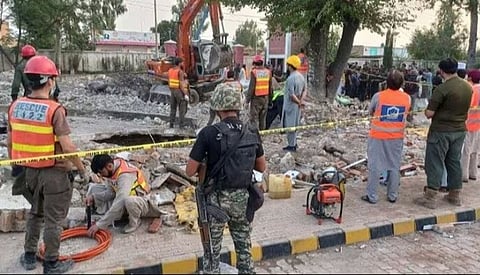 हंगू येथे २९ सप्टेंबर रोजी आत्मघाती स्फोटांनंतर इमारतीचा ढिगारा साफ करताना कर्मचारी.