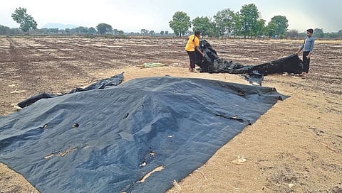 चांदवड : अवकाळी पावसाने हजेरी लावल्याने उघड्यावरील चारा झाकण्यासाठी शेतकऱ्यांची सुरू असलेली लगबग. (छाया : सुनिल थोरे)