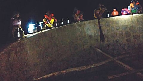 पेठ : तालुक्यातील चिखली गावात रात्रीच्या काळोख्यात बॅटरीच्या प्रकाशात विहिरीतील पाणी भरताना गावातील महिला. (छाया : नितीन पठाडे)