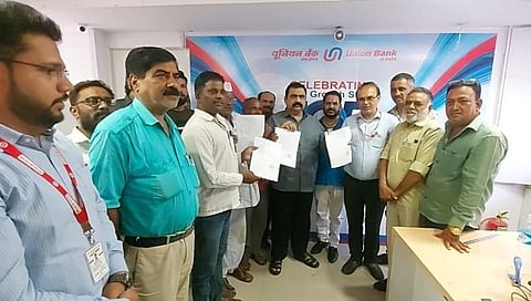 मनमाड : आमदास सुहास कांदे यांच्या हस्ते फसवणूक झालेल्या खातेदारांच्या खात्यात रक्कम परत करताना बँक अधिकारी व कर्मचारी.
(छाया : रईस शेख)