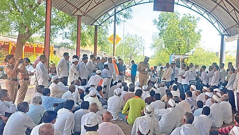 मालेगाव : मतदानावर बहिष्कार टाकलेल्या मेहुणे ग्रामस्थांशी चर्चा करताना तालुका पोलिस ठाण्याचे प्रभारी अधिकारी राहुल खताळ. दुसर्या छायाचित्रात मराठी शाळेत असलेल्या तिन्ही मतदान केंद्रांवरील शुकशुकाट. (छाया : नीलेश शिंपी)