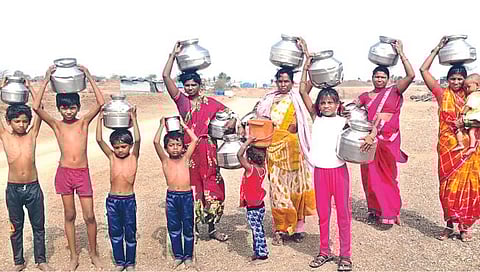 चांदवड : तालुक्यात भीषण पाणीटंचाई निर्माण झाल्याने हंडाभर पाण्यासाठी कडक उन्हातून तीन किमी अंतरावरून पाणी वाहताना आदिवासी महिलांसोबत अंगावर साधे कपडेही नसलेली त्यांची लहान लहान बालके.(छाया – सुनिल थोरे).