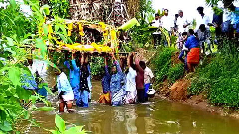 வாய்க்காலில் இறங்கி சடலத்தை தூக்கிச் செல்லும் அவலம்