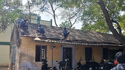 கூரை மீதேறி சுத்தம் செய்த மாணவர்கள்