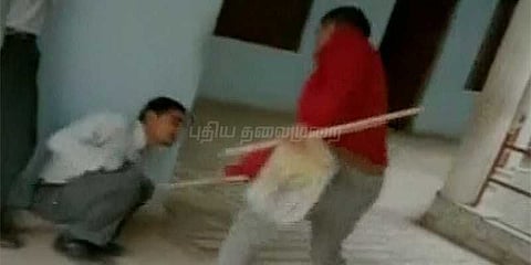 மாணவரை உருட்டுக்கட்டையால் தாக்கும் ஆசிரியர்