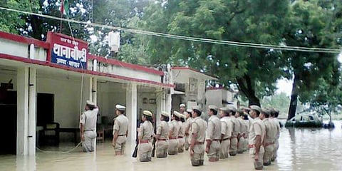 வெள்ளத்தில் நின்றபடி கொடியேற்றிய போலீஸார்: வைரலாகும் புகைப்படம்