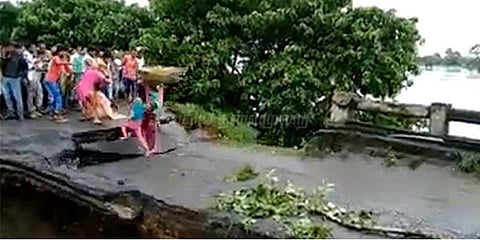 வெள்ளத்தில் அடித்துச்செல்லப்பட்ட பாலம்: 3 பேர் தத்தளிப்பு