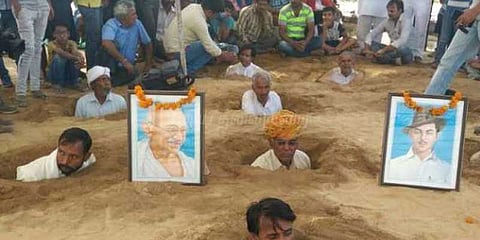 மண்ணில் புதைத்து கொண்டு விவசாயிகள் நூதன போராட்டம்