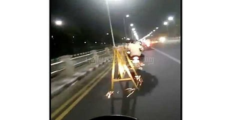 சாலைத் தடுப்பை இழுத்து சென்றபடி பைக் ஓட்டும் இளைஞர்கள்: வைரலாகும் வீடியோ