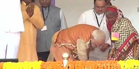 பழங்குடியின வயதான பெண்ணுக்கு குனிந்து காலணிகள் வழங்கிய பிரதமர் மோடி