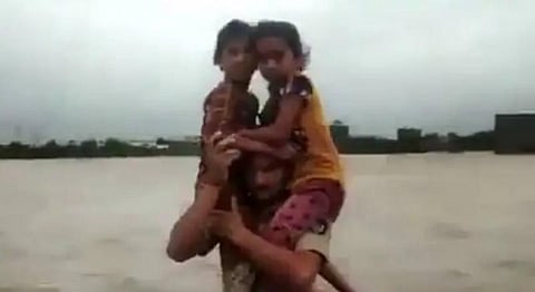 மார்பளவு வெள்ளநீரில் குழந்தைகளை தோளில் சுமந்த காவலர் - குவியும் பாராட்டு