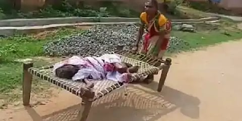 முதியோர் பணம் பெறுவதற்காக 100 வயது தாயைக் கட்டிலில் வைத்து இழுத்து வந்த மகள்