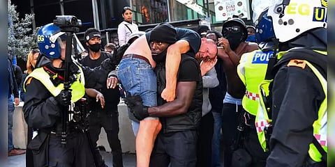 ‘காயம்பட்ட வெள்ளை நிறமுடையவரை தோளில் சுமந்த கருப்பு நிற மனிதர்’: வைரலான புகைப்படம்