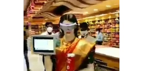 ஜவுளிக் கடையில் வாடிக்கையாளர்களுக்கு சானிடைசர் கொடுத்து வரவேற்கும் சேலை கட்டிய ரோபோ