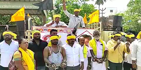 அதிமுகவுக்கு ஓட்டு போடாதீங்க: கை கால்களில் விலங்கிட்டு நூதன போராட்டத்தல் ஈடுபட்ட சுயேட்சை