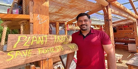 ‘மரங்களை காப்போம்’ என மரக்குடிலில் நின்று புகைப்படம்: விமர்சனத்திற்குள்ளான தோனி