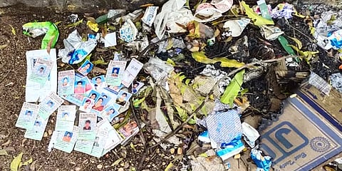 எரிந்த நிலையில் கட்டுக்கட்டாக குப்பைமேட்டில் கிடந்த வாக்காளர் அடையாள அட்டைகள்