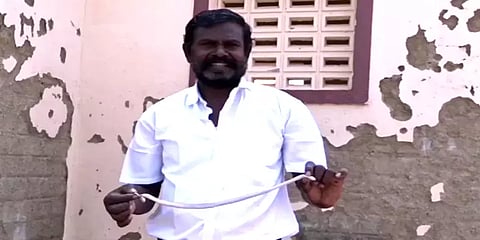 அரசுப்பள்ளி கழிவறைக்குள் புகுந்த கட்டுவிரியன் பாம்பு: லாவகமாக பிடித்த உடற்கல்வி ஆசிரியர்