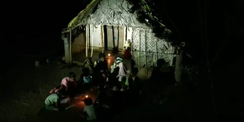 மின்வசதி இல்லாததால் மெழுகுவர்த்தி வெளிச்சத்தில் பாடம் படிக்கும் இருளர் இன குழந்தைகள்