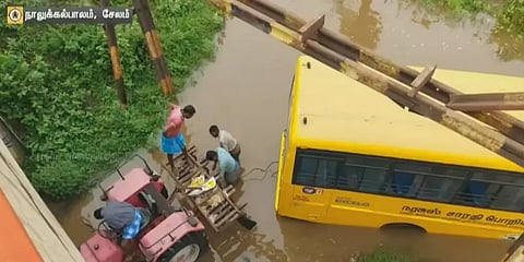 கல்லூரி பேருந்துடன் ஆற்றின் நடுவே சிக்கிய ஓட்டுநர்; ட்ராக்டர் மூலம் மீட்கப்பட்ட பரிதாபம்