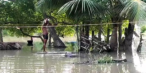கனமழையால் வீடுகளை சூழ்ந்த வெள்ளம் -மின்சாரம் இல்லாததால் இளைஞர் மழைநீரில் குளித்த அவலம்