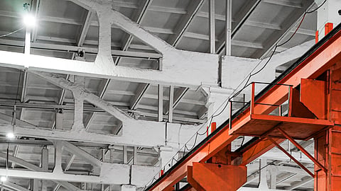 Industrial manufacturing facility interior with large production infrastructure and automated engineering equipment.