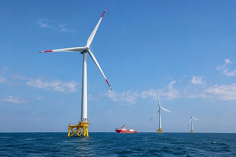 Offshore wind turbines installed on marine foundations with a service vessel operating nearby, illustrating offshore wind installation and maintenance infrastructure.