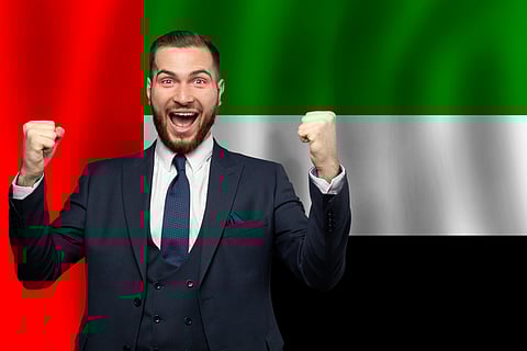 UAE happy businessman on the background of flag of United Arabian Emirates