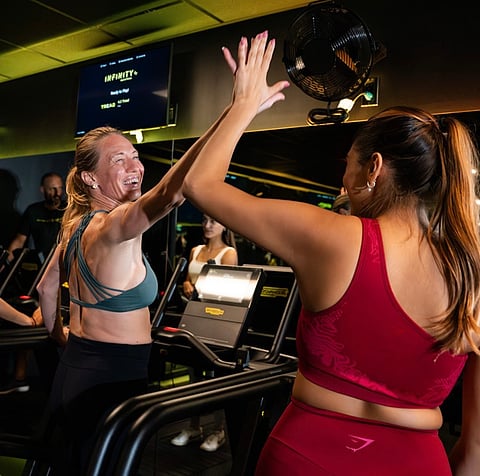 Participants share a high-five during an INFINITY Beyond Fitness workout